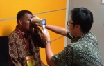 学生于印尼一间诊所内，测试使用手提式眼底相机检测糖尿眼的效果。 - 香港科技大学