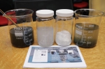汉元生物科技有限公司所研发的絮凝剂(有盖容器)能将污水(左方烧杯)分隔成水与污泥(右方烧杯)之余，更可将污泥分解与发酵 - 香港科技大学